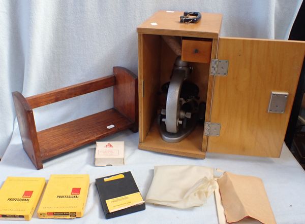 A BOXED BIOLOGICAL MICROSCOPE WITH A BOOK RACK