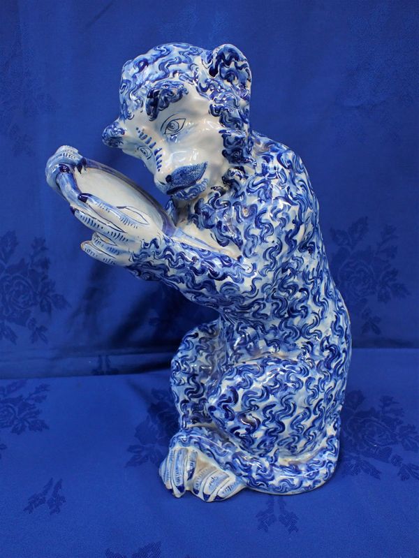 A DELFT MONKEY, HOLDING A LOOKING-GLASS