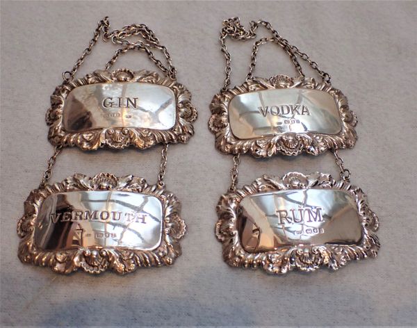 A FOUR MATCHING SILVER BOTTLE LABELS