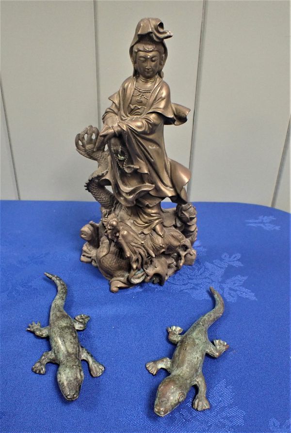 A CHINESE BRONZE FIGURE OF GUAN YIN STANDING ON A FIERY DRAGON