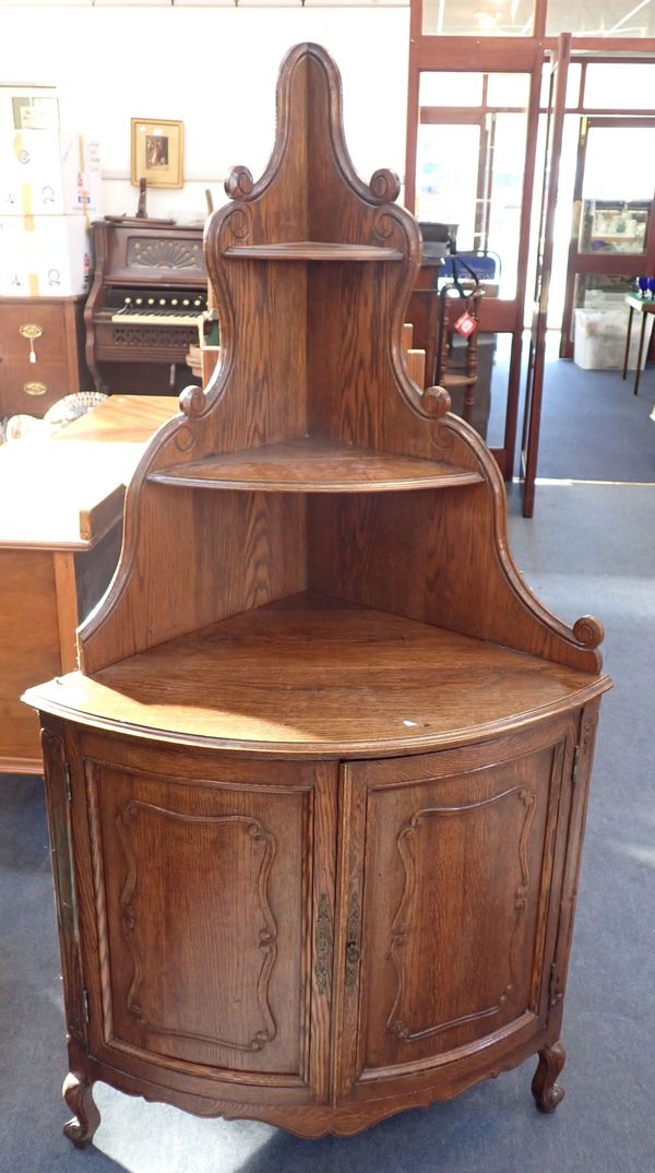 A FRENCH PROVINCIAL STYLE CARVED OAK CORNER CABINET