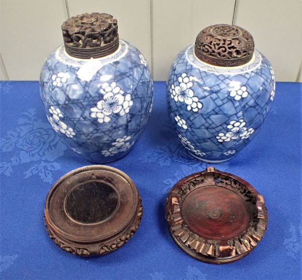 TWO PRUNUS GINGER JARS WITH CARVED LIDS AND STANDS