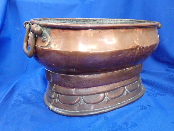 AN OVAL COPPER JARDINIERE, ON  MOULDED FOOT