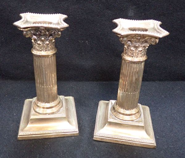 A PAIR OF LOADED SILVER CANDLESTICKS