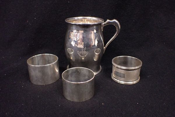 THREE SILVER NAPKIN RINGS WITH A BARREL FORM SILVER MUG