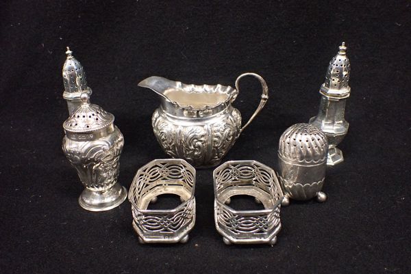 A REPOUSSE SILVER CREAM JUG, PEPPERETTES