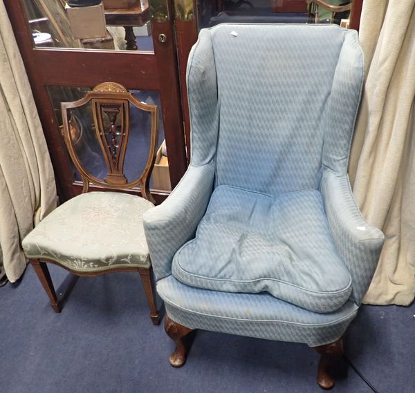 AN UPHOLSTERED WING-BACK ARMCHAIR, WITH SCROLLING ARMS