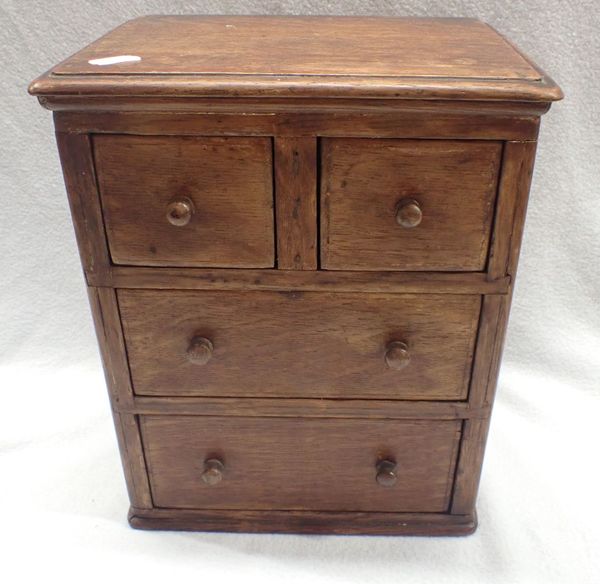 A NAIVELY MADE 19TH CENTURY OAK MINIATURE CHEST OF DRAWERS