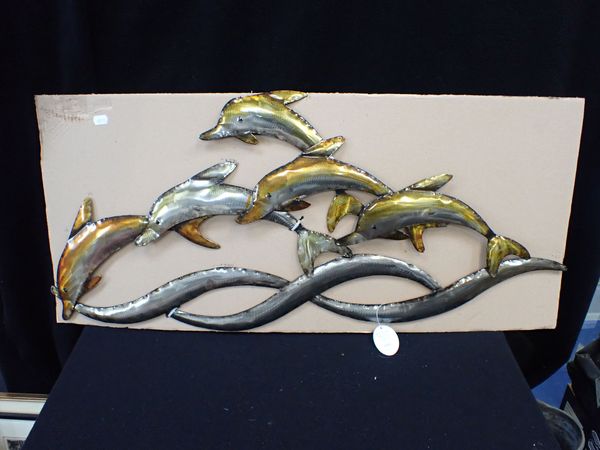 A METAL WALL ART PIECE DEPICTING DOLPHINS