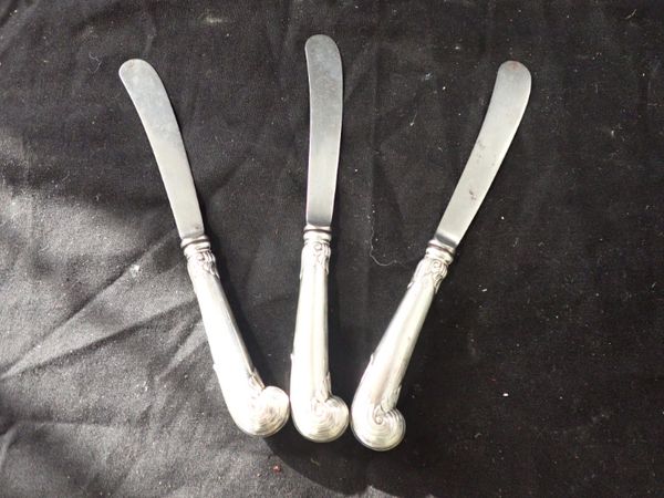 A SET OF SIX SILVER HANDLED BUTTER KNIVES