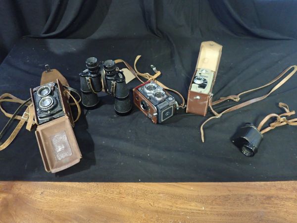 A SMALL GROUP OF CAMERAS AND BINOCULARS