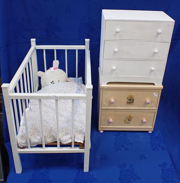 A WOODEN DOLL'S COT WITH TWO MINATURE CHESTS OF DRAWERS