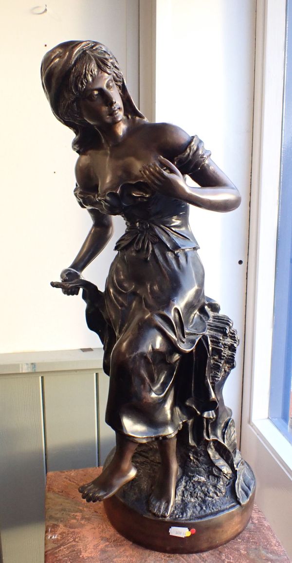 A PATINATED BRONZE STATUE OF A YOUNG WOMAN