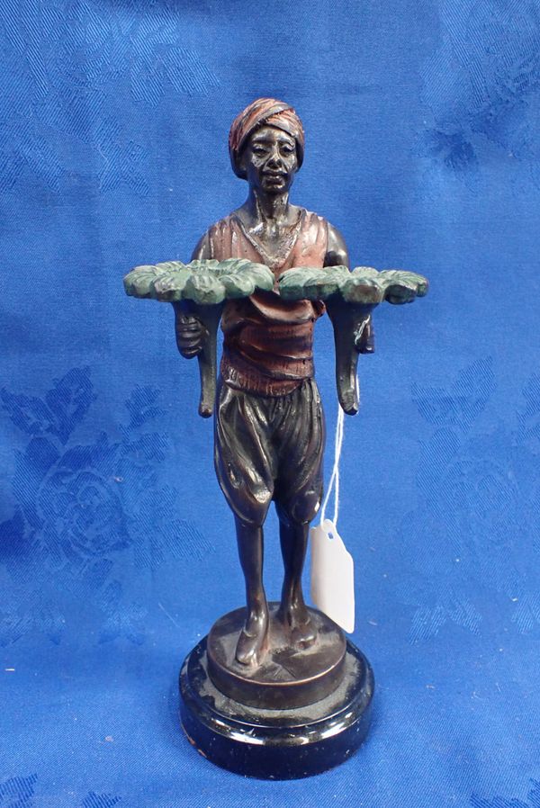 A COLD PAINTED BRONZE NUBIAN CANDLE HOLDER