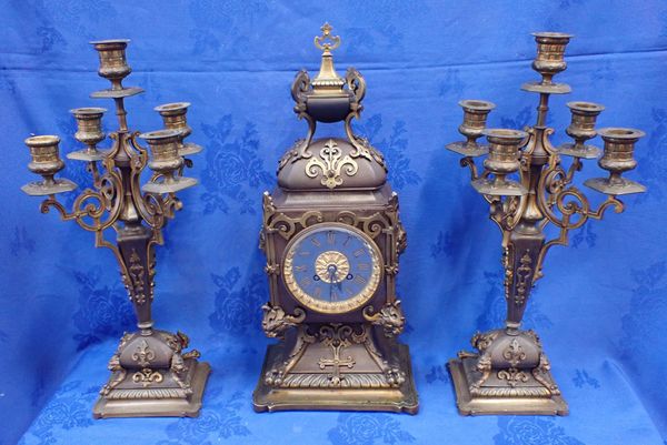 A PATINATED BRASS CLOCK GARNITURE