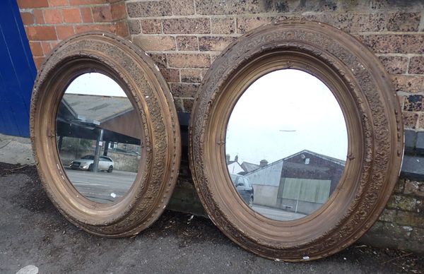 A PAIR OF OVAL GILTWOOD AND COMPOSITION FRAMED WALL MIRRORS