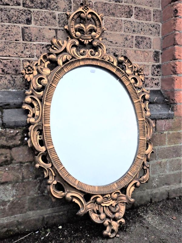 A CARVED AND GILTWOOD FRAMED  OVAL MIRROR