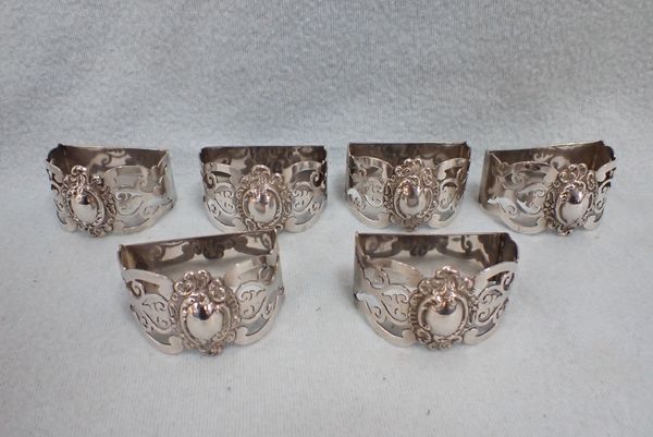 A SET OF SIX UNMARKED WHITE METAL NAPKIN RINGS