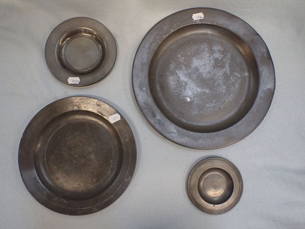 A PEWTER PLATE, AND THREE SMALLER, THE SMALLEST WITH TURNED RIM
