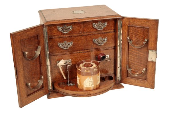 AN EDWARDIAN OAK SMOKER'S CABINET