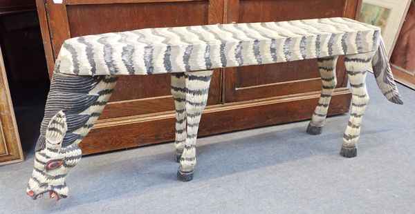 A CARVED WOODEN BENCH IN THE FORM OF A ZEBRA