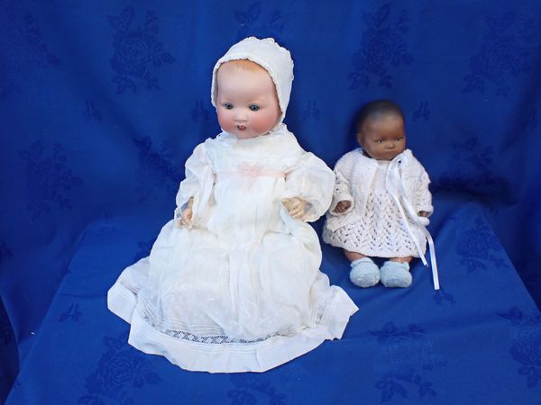 A BISQUE HEADED SMALL BLACK BABY DOLL STAMPED 'AM'