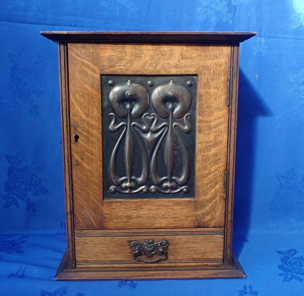 AN EDWARDIAN ART NOUVEAU OAK SMOKER'S CABINET