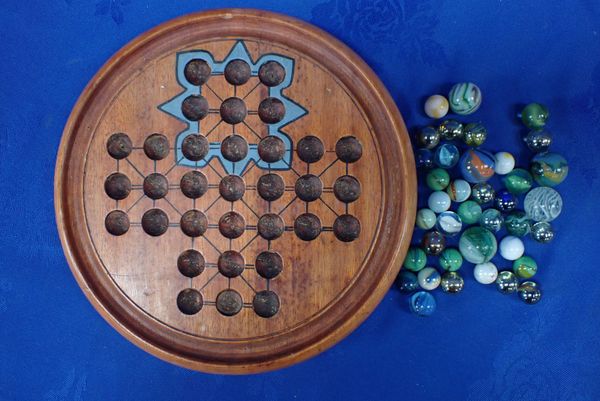 A TURNED SOLITAIRE BOARD AND MARBLES