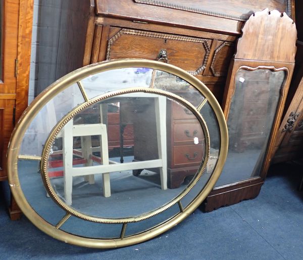 A REGENCY STYLE OVAL WALL MIRROR WITH  SHAPED MARGINS