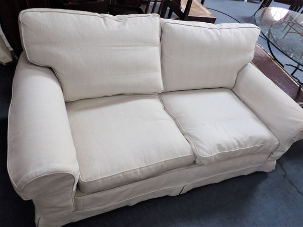 A TWO SEATER SOFA, WITH CREAM LOOSE COVERS