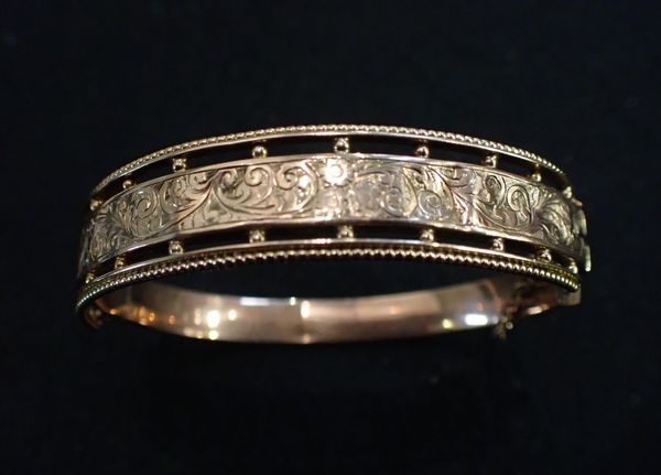 A YELLOW METAL BRACELET, ENGRAVED