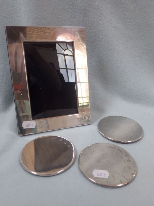 A SILVER PHOTOGRAPH FRAME WITH SILVER COASTERS