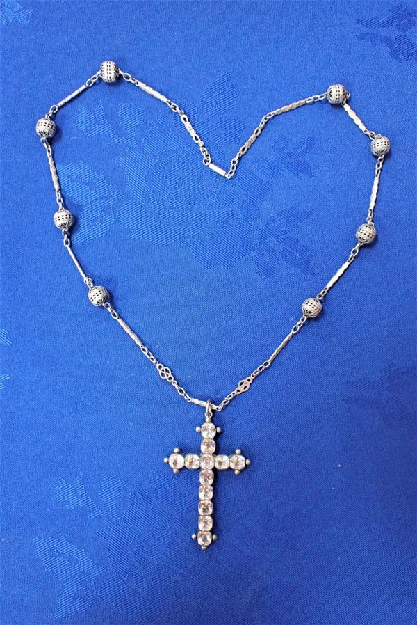 AN EARLY 20TH CENTURY WHITE METAL AND PASTE CROSS