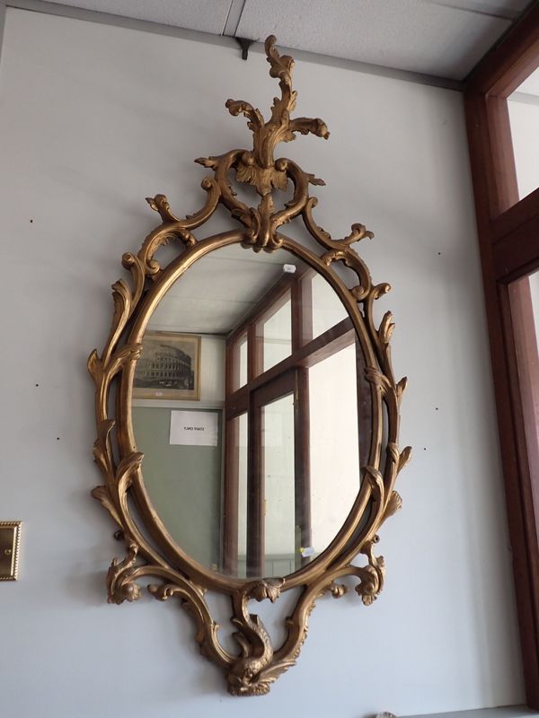 A GEORGE III GILTWOOD ROCOCO STYLE OVAL WALL MIRROR