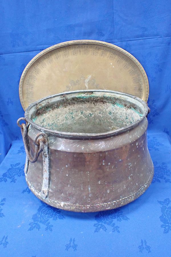 A LARGE COPPER COOKING POT WITH IRON HANDLES