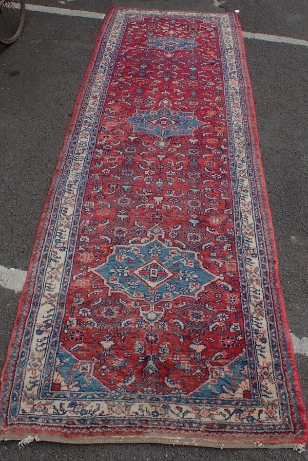 A RED GROUND PERSIAN RUNNER