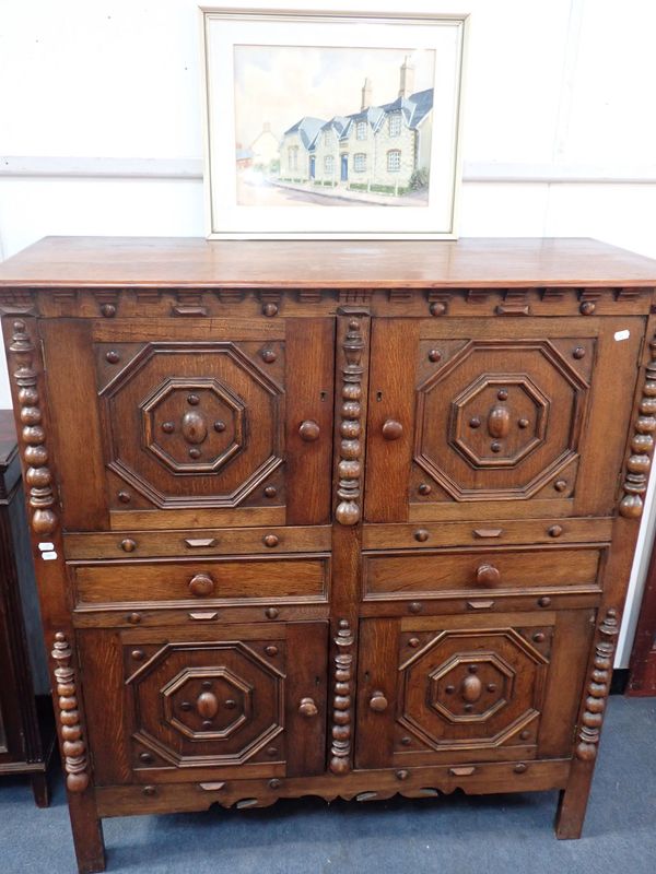 AN EARLY 20TH CENTURY JACOBEAN STYLE OAK CUPBOARD