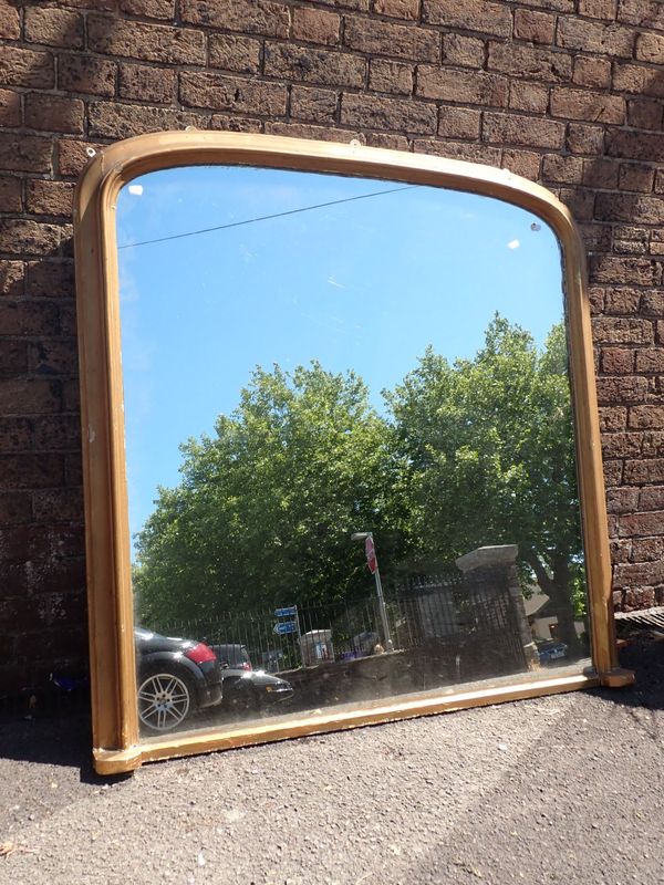 A GILT FRAMED ARCHED TOP OVERMANTEL MIRROR