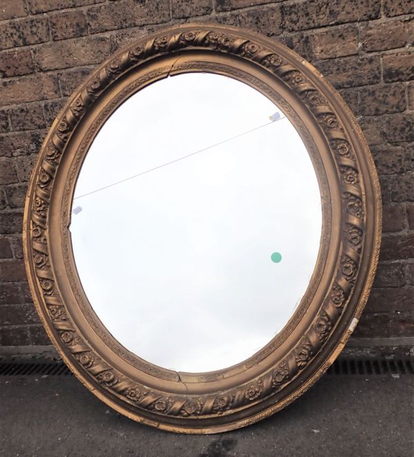 A 19TH CENTURY HEAVILY MOULDED GILT OVAL FRAMED MIRROR