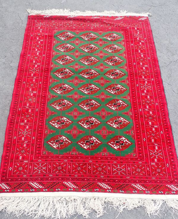 A MODERN GREEN GROUND RUG