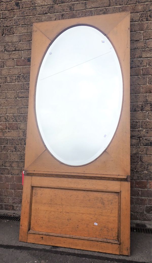 A BEVELLED OVAL MIRROR, IN AN OAK FRAME