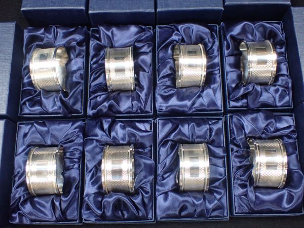 A SET OF EIGHT ENGINE-TURNED SILVER NAPKIN RINGS