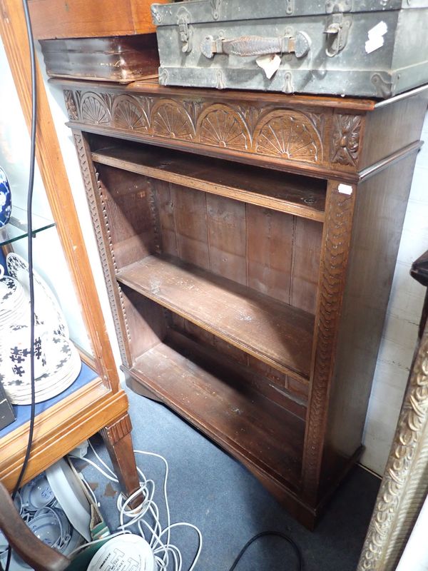 AN OAK OPEN BOOKCASE WITH CARVED DECORATION