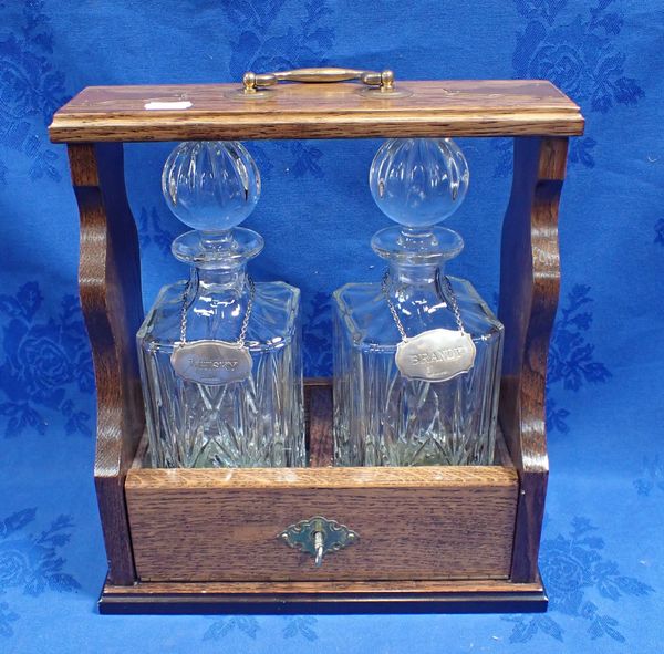 AN OAK CASED TANTALUS WITH TWO SILVER DECANTER LABELS