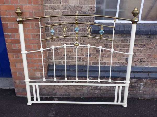 AN EDWARDIAN  STYLE IRON AND BRASS BED HEAD