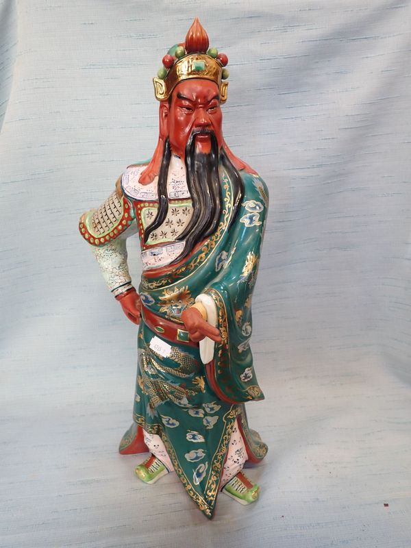 A PORCELAIN FIGURE OF A STANDING WARRIOR