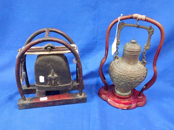 A TIBETAN BRONZE BELL ON WOODEN STAND