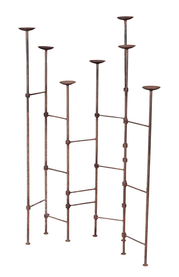 A WROUGHT IRON SCREEN OF PRICKET CANDLESTICKS