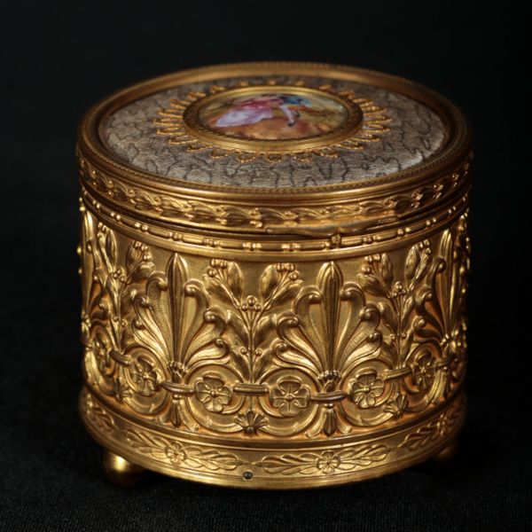 A FRENCH EMBOSSED BRASS CYLINDRICAL MUSICAL JEWELLERY BOX