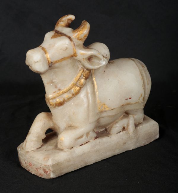 AN INDIAN PARCEL GILT ALABASTER FIGURE OF SACRED COW